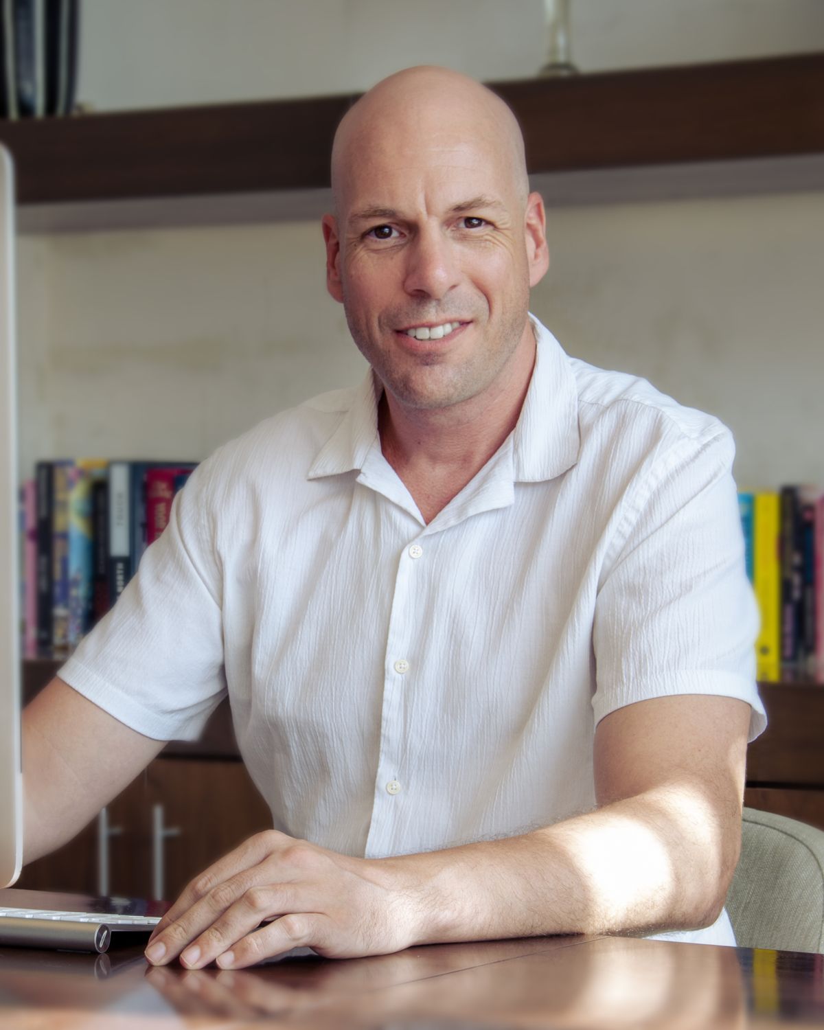 Martin Champagne smiling at his desk in his studio